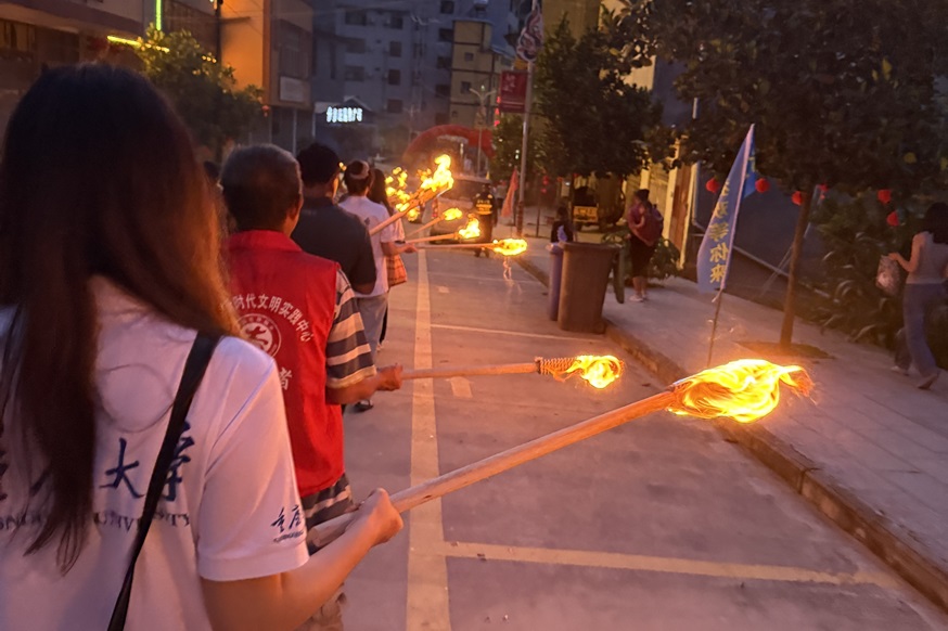 图为服务团师生手持火把参与巡游队伍.jpg